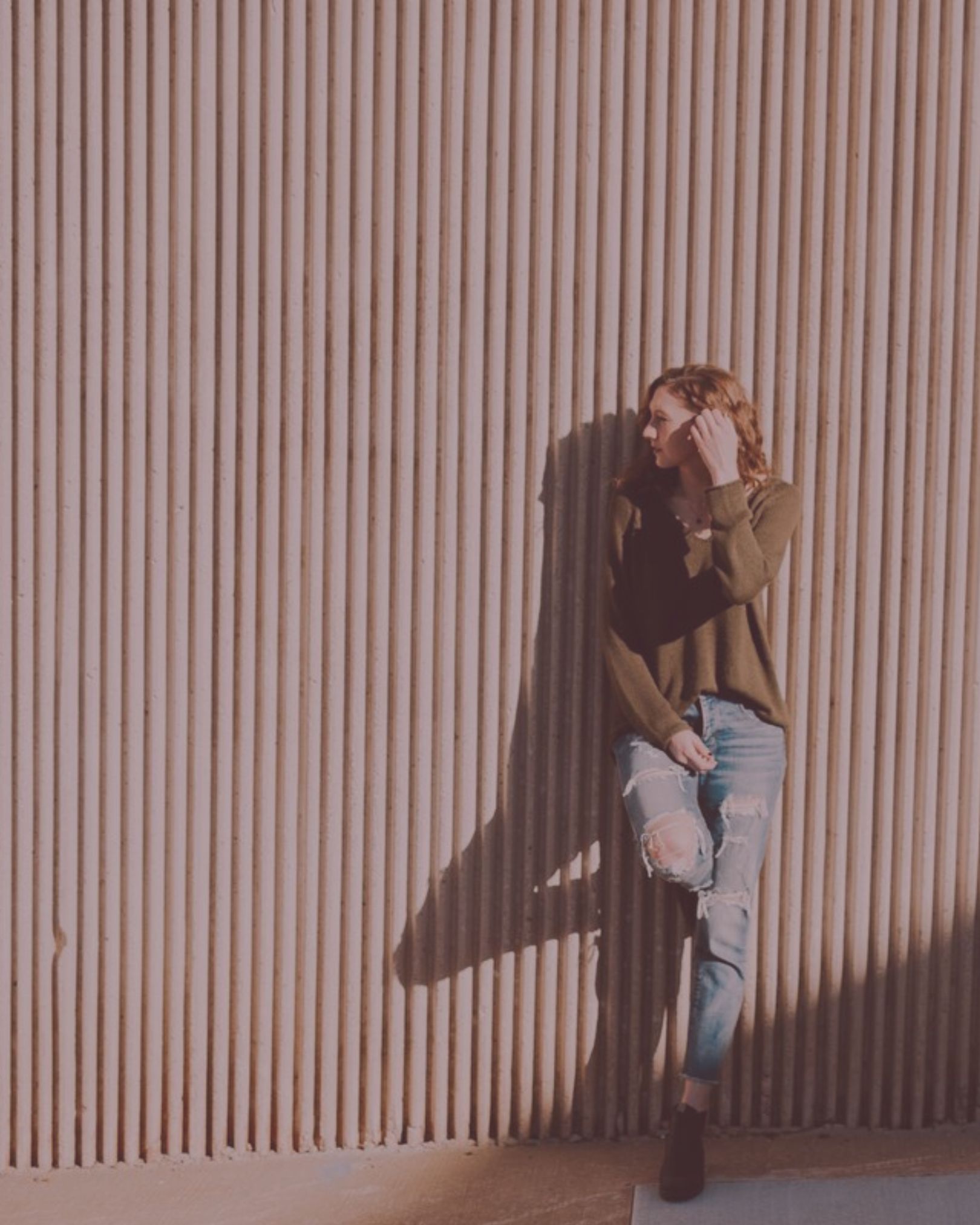 Woman leaning against a wall.